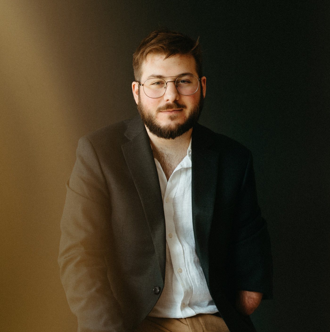 Christian Dyble, music teacher in Appleton, in a dark blazer against a dark backdrop
